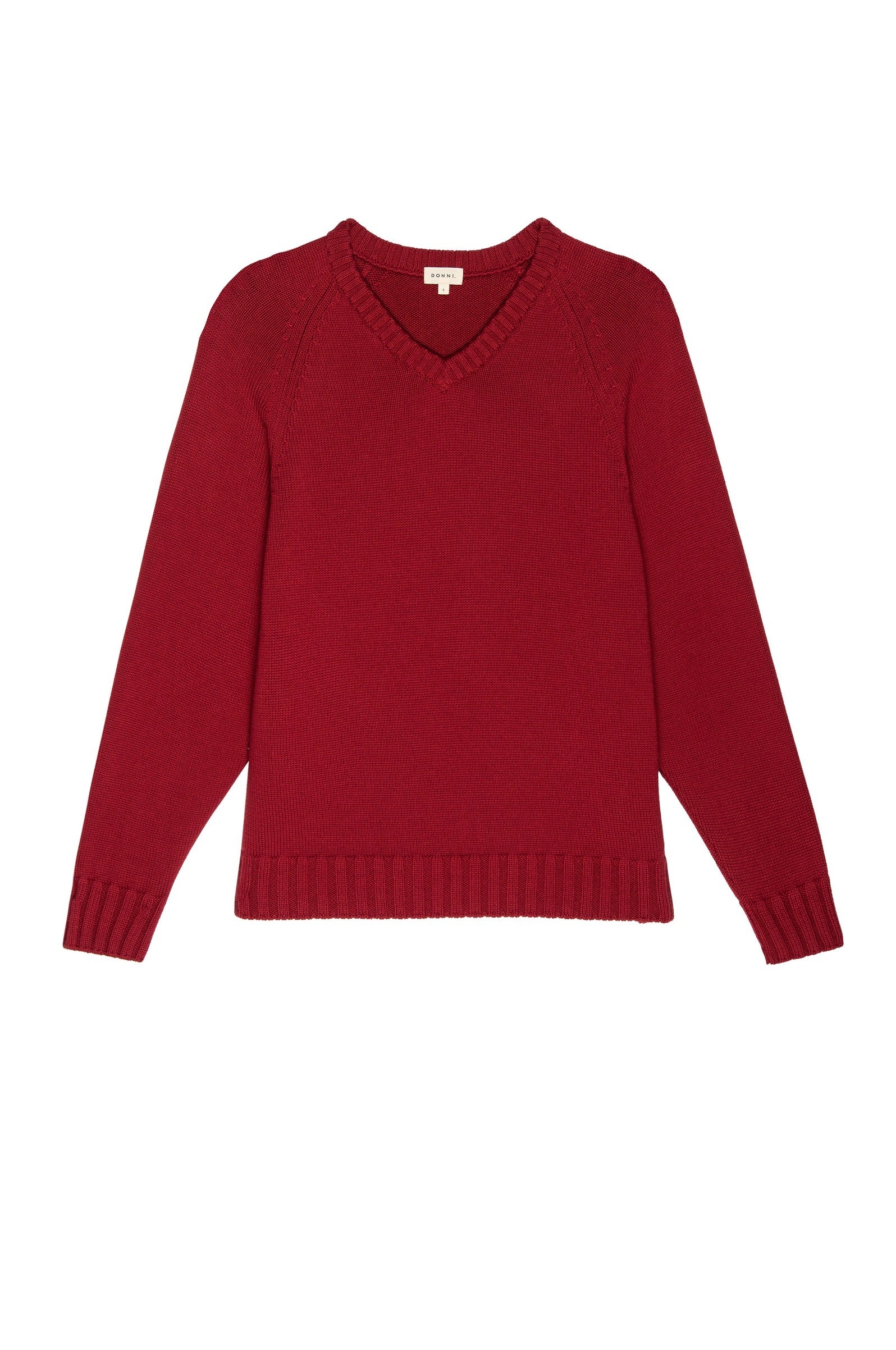 A red, long-sleeve V-neck sweater from Donni, named "Donni The Cotton V Neck Sweater," is laid flat. Crafted from premium Italian Cashmere, this sweater features ribbed detailing along the neckline, cuffs, and hem for a textured finish. The knit fabric ensures a cozy and warm appearance with no visible embellishments or patterns.