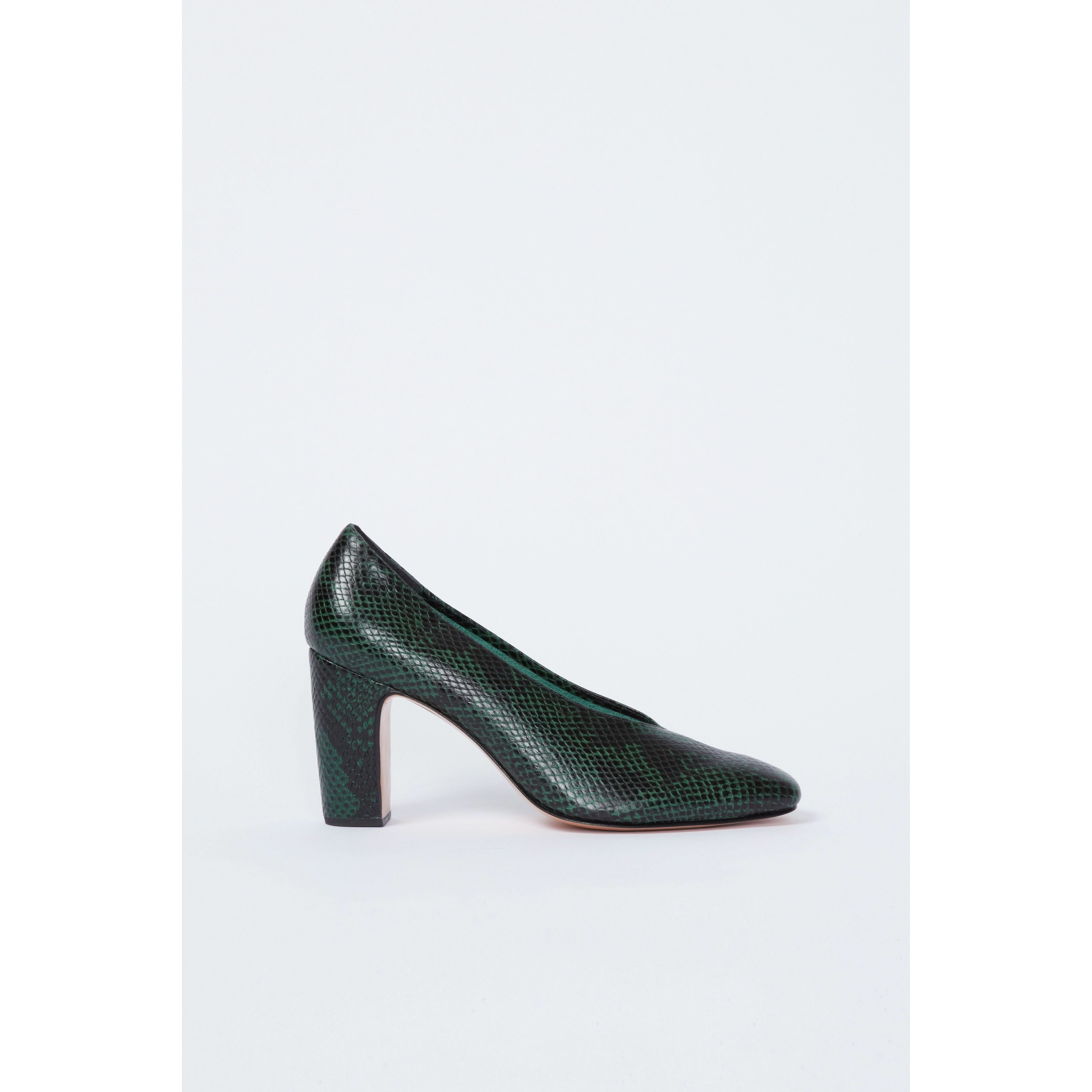 The Rachel Comey Chloris Pump in green features a textured reptile-skin pattern, an almond toe, and a chunky block heel, all highlighted against a plain white background.