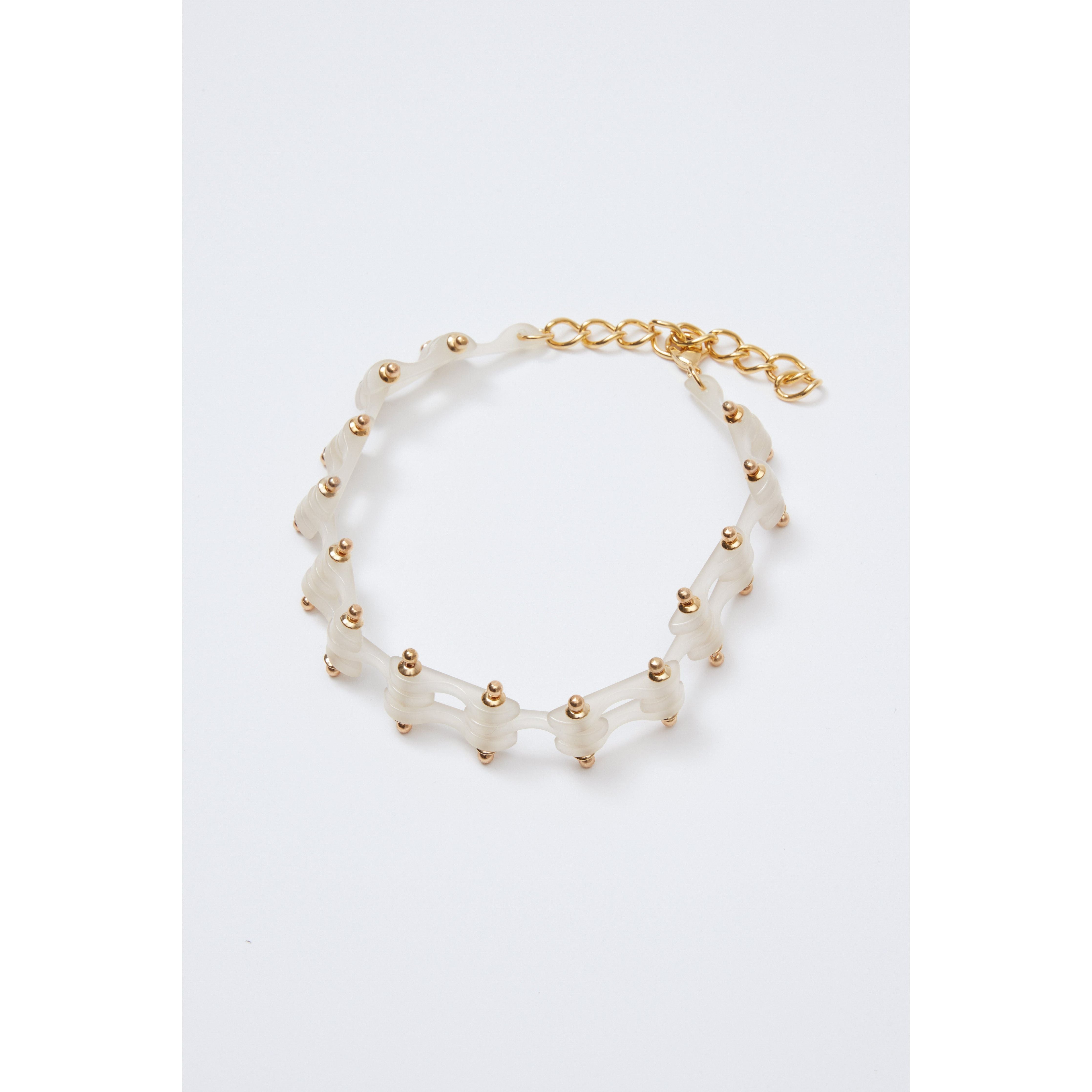 The Rachel Comey Bedford Choker is a gold-tone bracelet featuring a delicate chain design with interlocking links and evenly spaced bead accents. It includes an adjustable lobster clasp with extra chain links and is presented against a white background.