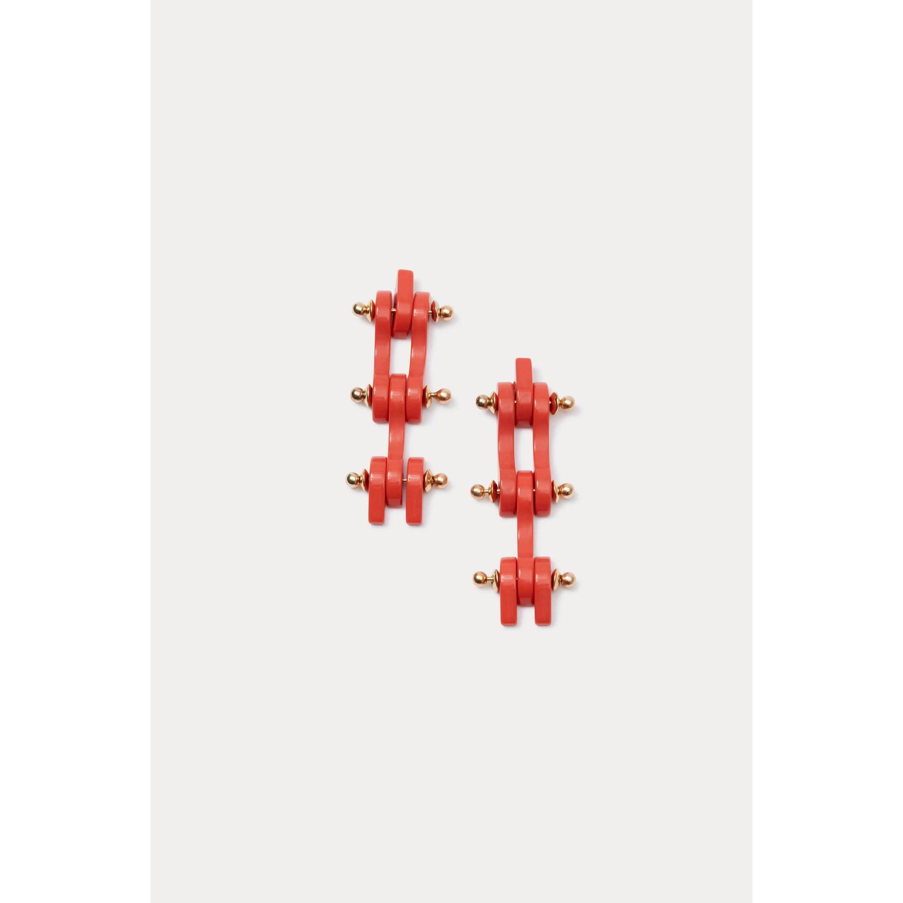 A pair of striking Rachel Comey Bedford Earrings in Coral, featuring rectangular shapes and small gold accents, is arranged vertically on a plain light background. These exquisite pieces are made in Italy, ensuring superior craftsmanship and style.