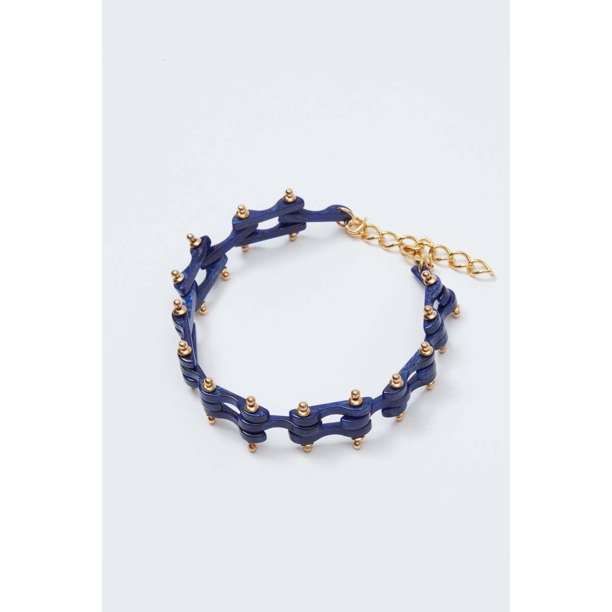 The Rachel Comey Bedford Chocker by Rachel Comey features interlocking links in vivid blue with small gold studs and an adjustable gold chain clasp, resembling a stylized, delicate bike chain.