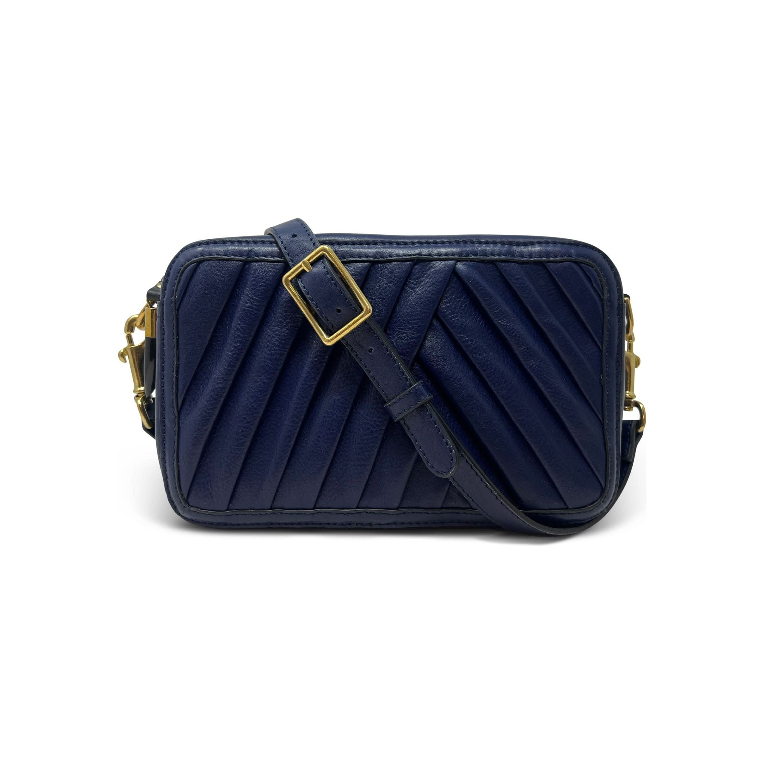 New Style Alert: Introducing the Kempton & Co Amberleigh Crossbody Bag - Pleated Indigo. This small, rectangular navy blue leather bag boasts intricate quilted diagonal stitching and a chic gold buckle on its adjustable strap. Drawing inspiration from vintage travel bags, it features elegant gold hardware accents, including a zipper and clasps. Photographed against a plain white background, it's the perfect blend of classic style and modern functionality.