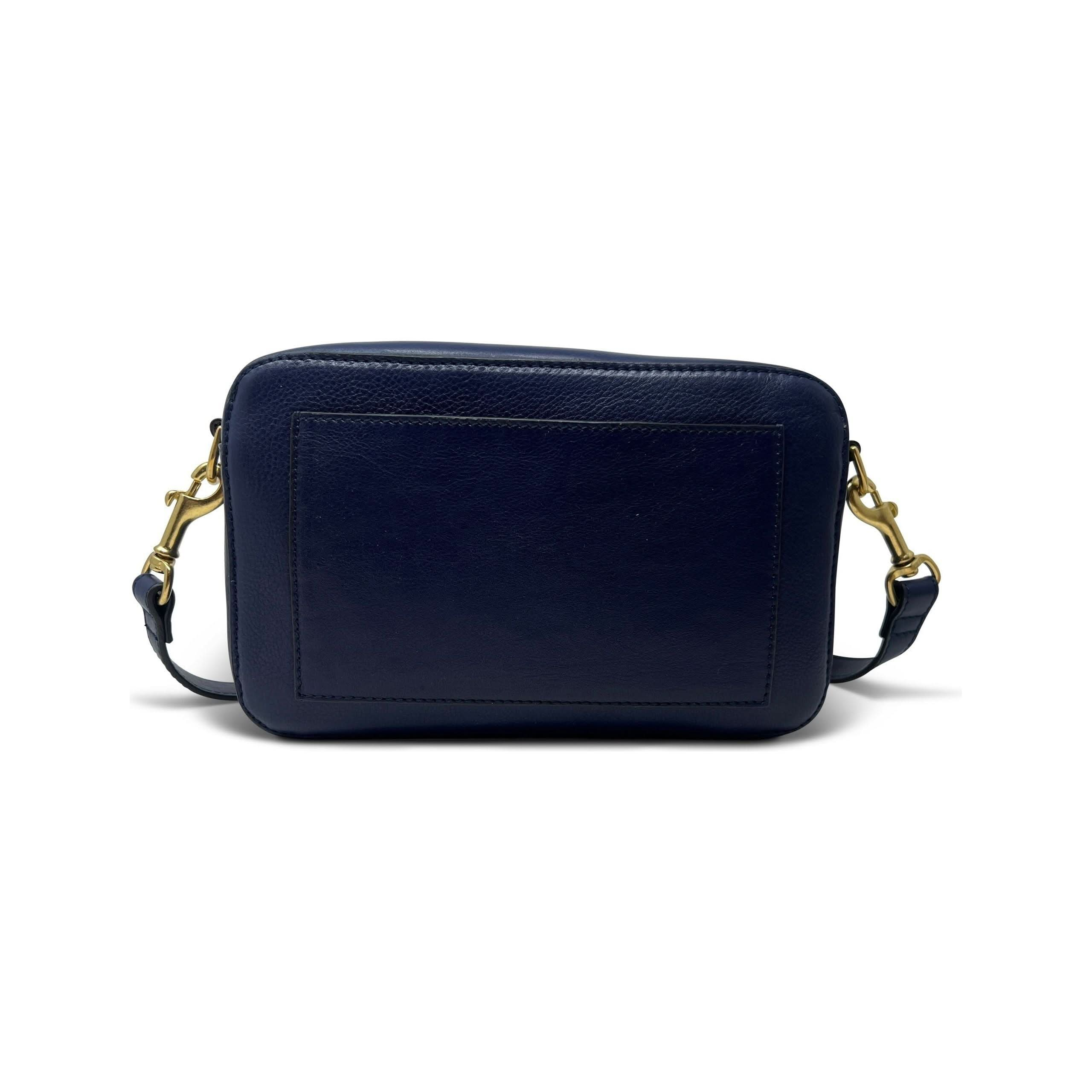 The Kempton & Co Amberleigh Crossbody Bag - Pleated Indigo is a small, rectangular navy blue leather shoulder bag with gold hardware and an adjustable strap. It boasts a plain, sleek design with a smooth surface and a stitched border around a central panel on the front, reminiscent of vintage travel bags. New Style Alert: it features an enticing indigo hue.