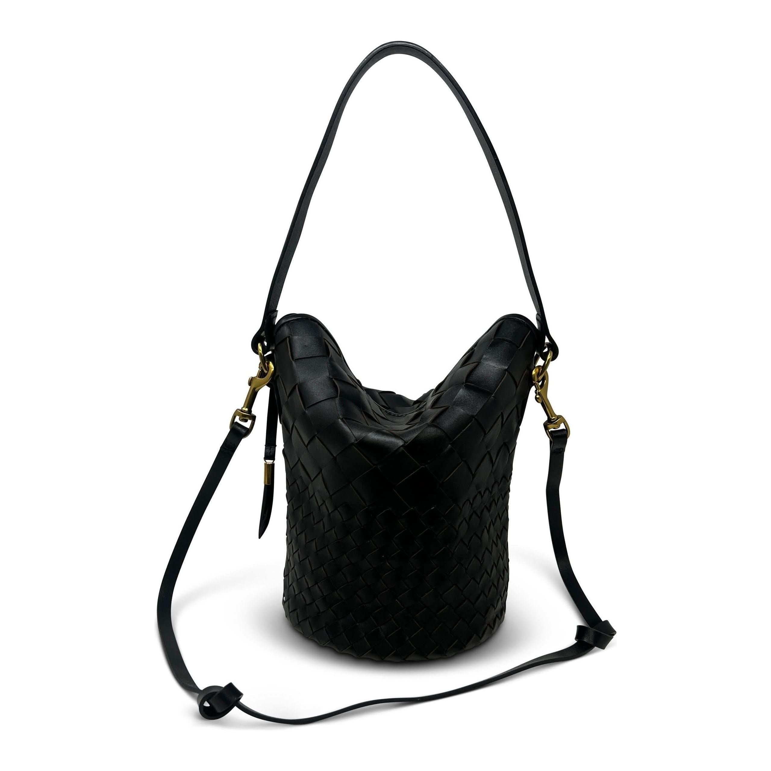 The Kempton & Co Richmond Bucket Bag - Black Threaded Weave is a stylish bucket bag crafted from black leather with an intricate woven design. It features a single over-the-shoulder strap, embroidered handles with gold-tone hardware, and boasts a slouchy, relaxed shape with an elegant and modern aesthetic.