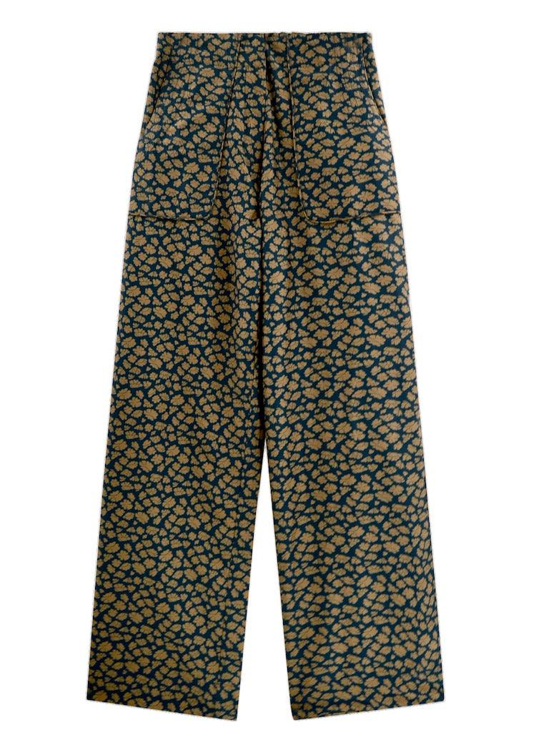 Mirth Tivot Pant Navy Lilypad: High-waisted, wide-legged pants featuring a dark blue and beige lily pad floral pattern. Crafted from cotton with a textured, jacquard-like finish. Made by the brand Mirth in India.