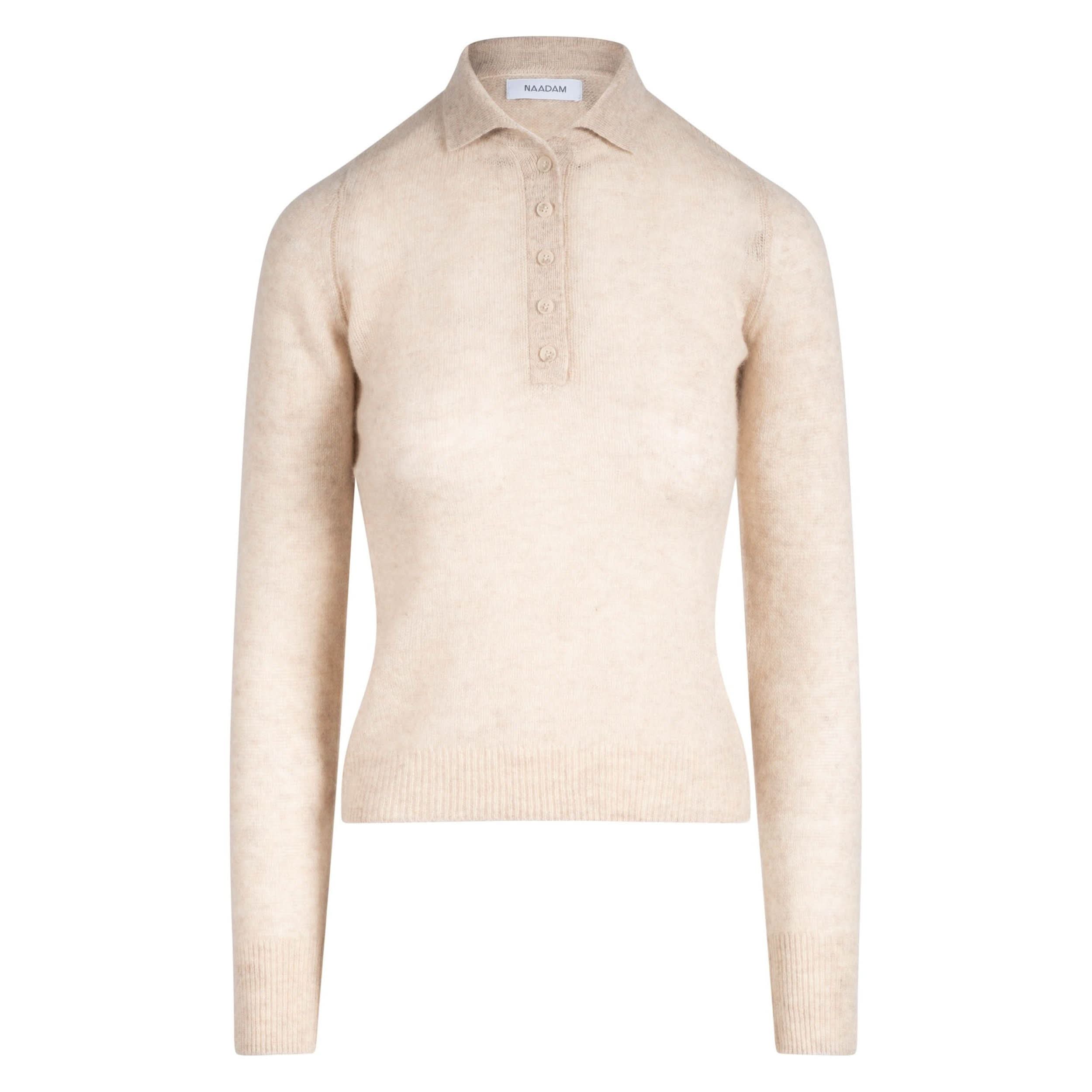 The Naadam Featherweight Cashmere Polo by Naadam is a beige long-sleeve knit sweater featuring a ribbed hem and cuffs, a polo collar, and a half-button placket down the front. This luxurious cashmere sweater has a fitted silhouette and boasts a soft, cozy texture.