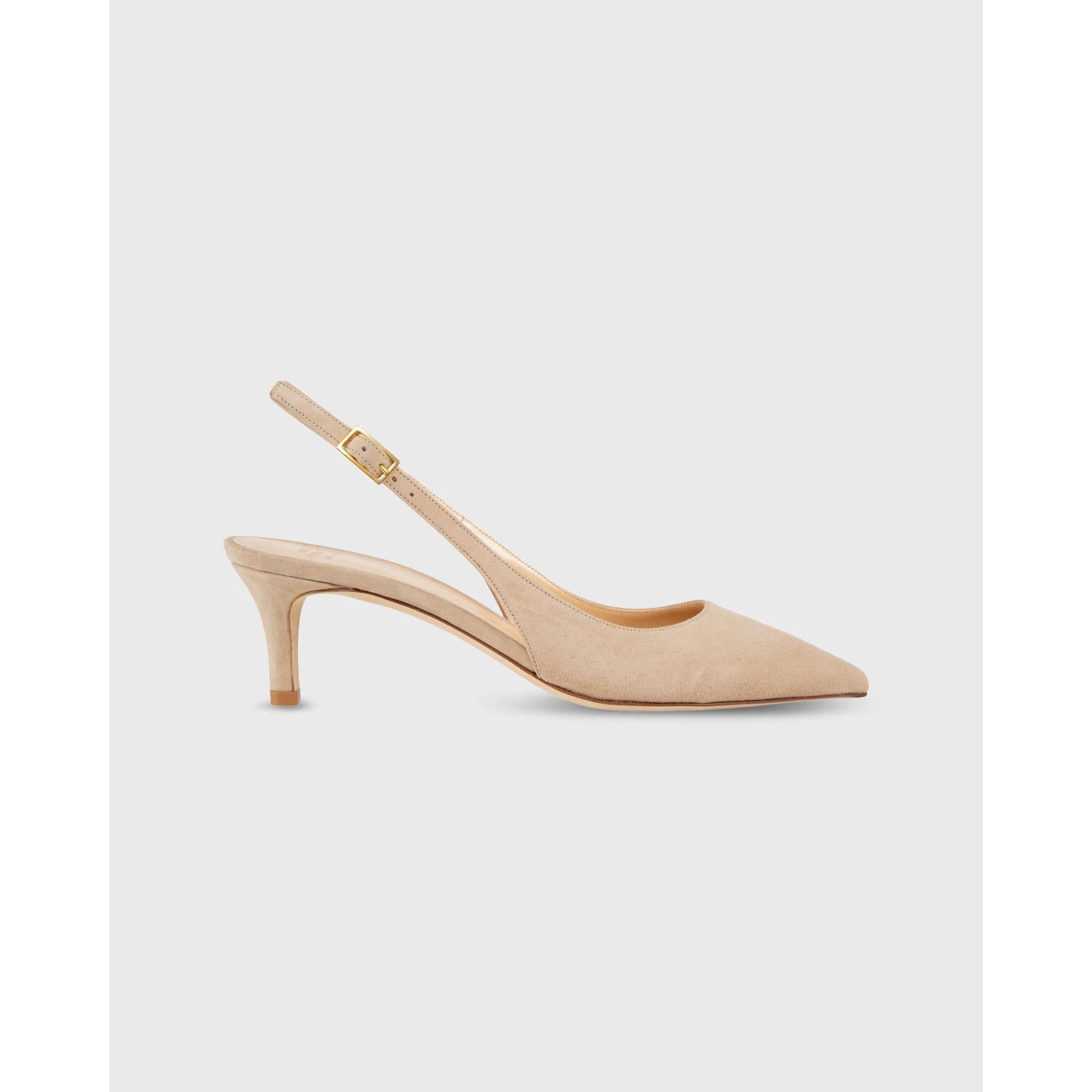 The Ann Mashburn Kitten Heel Slingback in pebble suede showcases a retro allure with its pointed toe and mid-height heel. Crafted from sumptuous lambskin leather, it includes an adjustable ankle strap with a gold buckle, echoing the classic Mary Jane style. The shoe is elegantly presented on a plain white background.