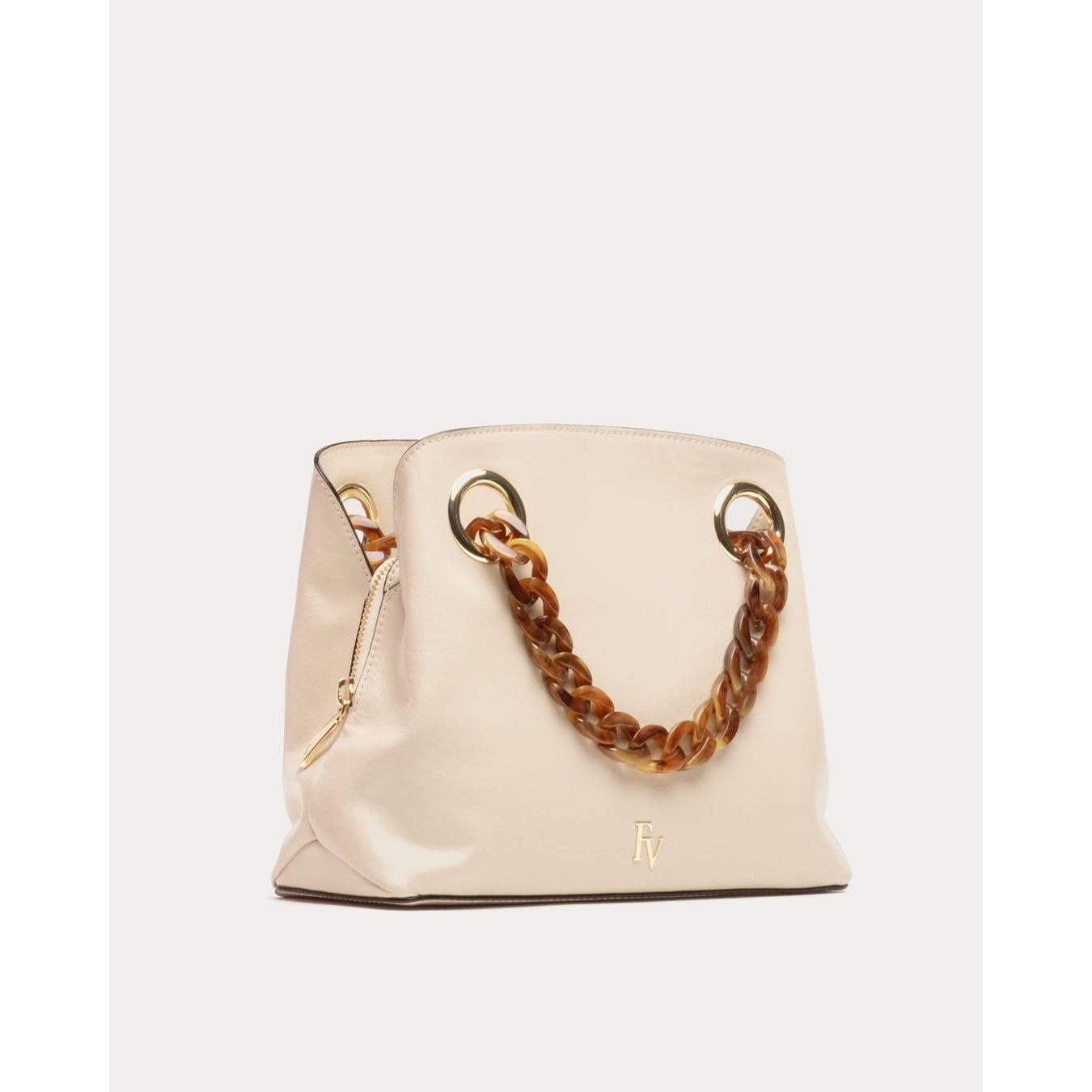 Introducing the Frances Valentine Skip Tote in Crinkled Leather Oyster: This elegant tote showcases a stylish tortoise chain handle threaded through large gold rings, complemented by exquisite gold accents. The subtle gold logo on the front adds a touch of sophistication, while a zippered side pocket ensures practicality. Set against an off-white backdrop, this beige handbag is a timeless accessory from Frances Valentine.