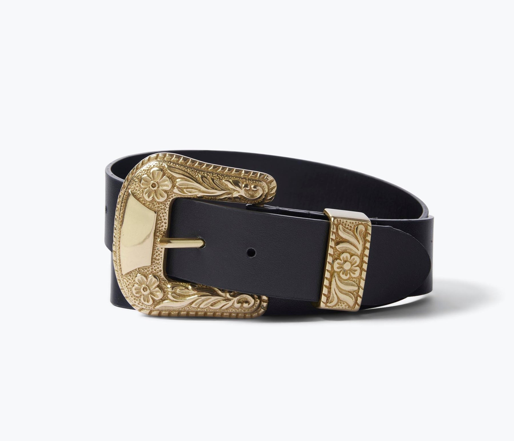 The Freda Salvador Laia Belt is a black Italian leather accessory featuring an ornate, oversized brass buckle and tip. The buckle exhibits intricate floral and scroll designs, adding an elegant touch to this natural waist belt. When neatly coiled, the belt highlights the exquisite details of the buckle and tip.