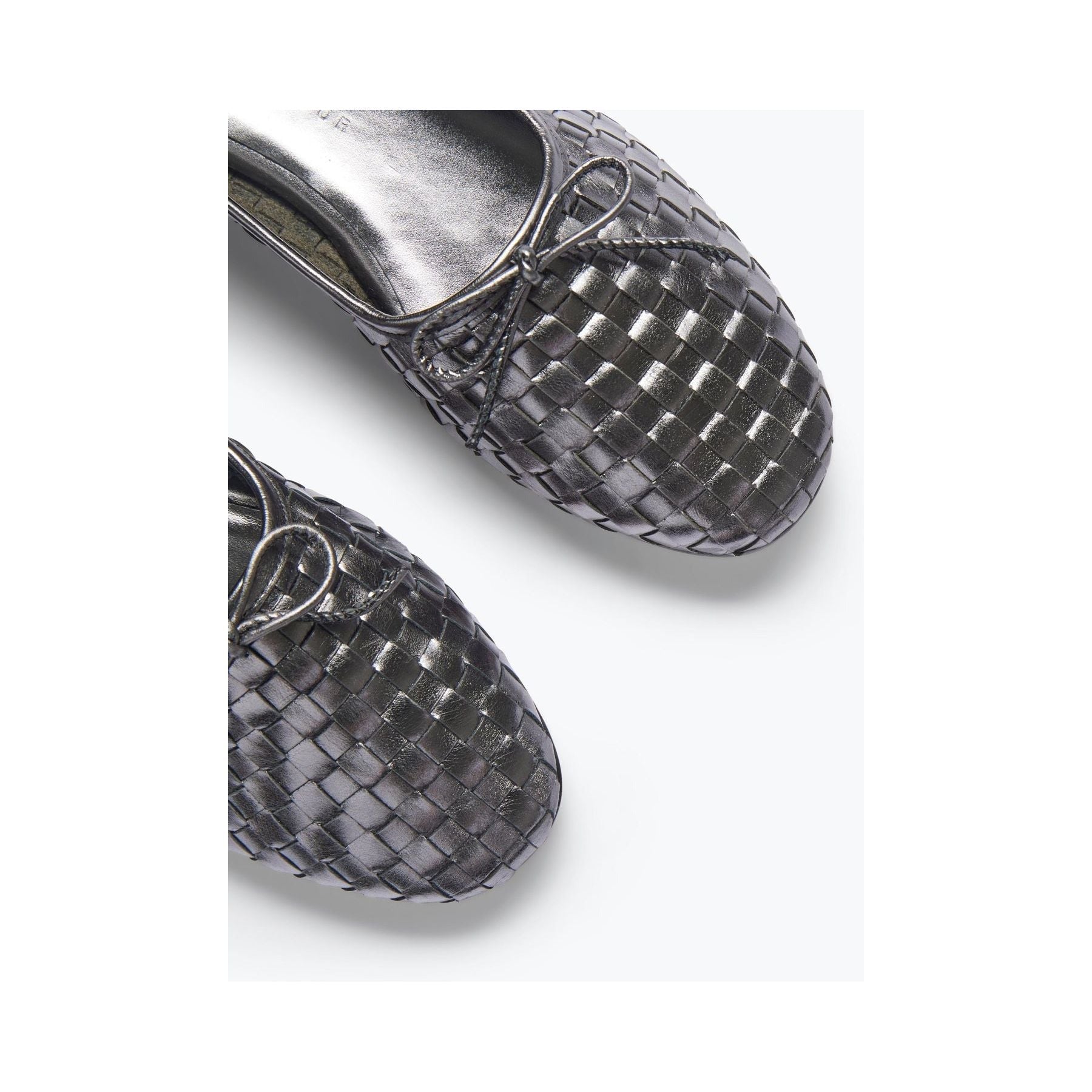 A close-up of two intricately textured Freda Salvador Roma Round Toe Ballet Flats in gunmetal on a light background, showcasing elegant craftsmanship and high-quality leather with a detailed crisscross pattern.