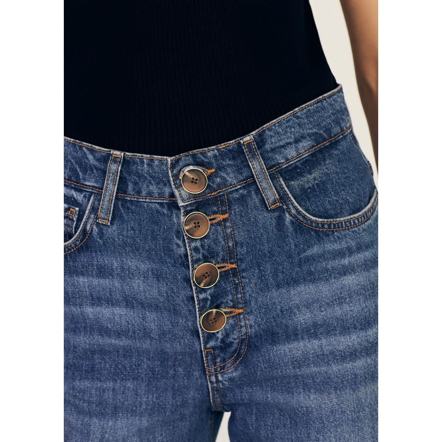 Close-up of a person wearing high-waisted Derek Lam 10 Crosby Simona Cuffed Straight Leg jeans with prominent brown buttons. The rigid denim jeans from Derek Lam feature orange stitching, a snug fit around the waist, and classic 5-pocket construction. The person is wearing a black top tucked into the jeans.